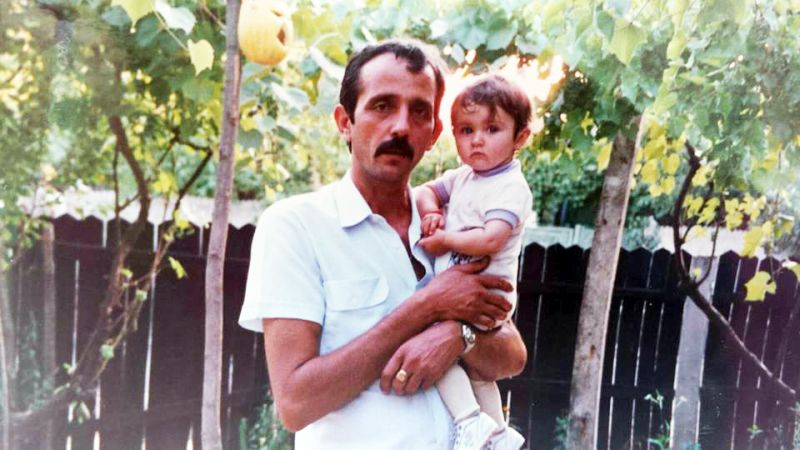 Fotografia alăturată o înfăţişează pe tânăra interpretă de muzică populară din zona Gorjului, Raluca Elena Căpitănescu, un nume care a stat pe buzele multora în ultimele zile. Aceasta apare cu o figură angelică în braţele protectoare ale unui membru al familiei, când nu împlinise nici vârsta de 2 ani. Aflată la vârsta tinereţii, folclorista a dat piept cu problemele, în ultima perioadă trecând printr-o perioadă dificilă în viaţa personală. Iubitul său, boxerul Iulian Ghişe, a fost ridicat săptămâna trecută de DIICOT şi arestat pentru trafic de droguri.