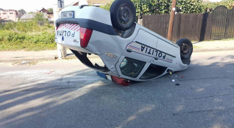 Mașina Poliției, răsturnată după ce a fost lovită de o Dacie