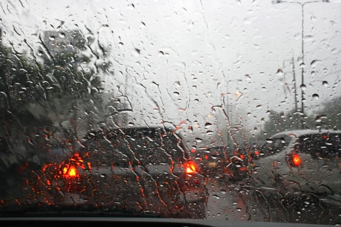 39180814 - road view through car window with rain drops, driving in rain.